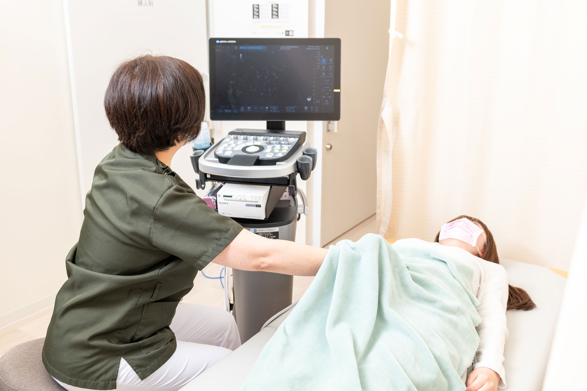 女性医師が患者様へ診察・相談を行っている様子